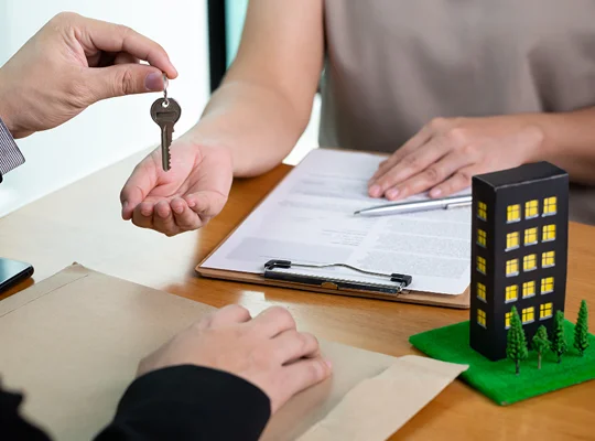 a person handing over a key to another person