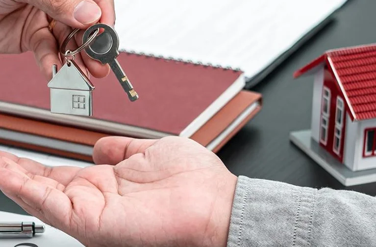 a hand holding a keychain with a house shaped keyring