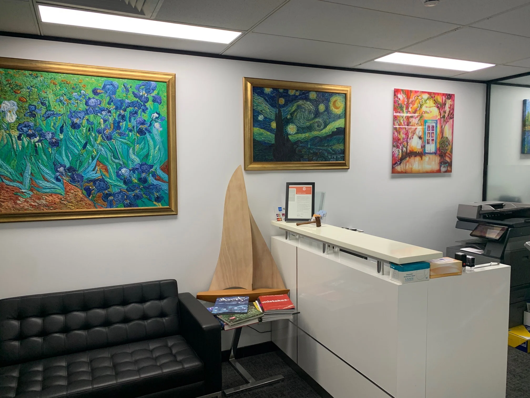 a reception desk with a chair and a painting on the wall
