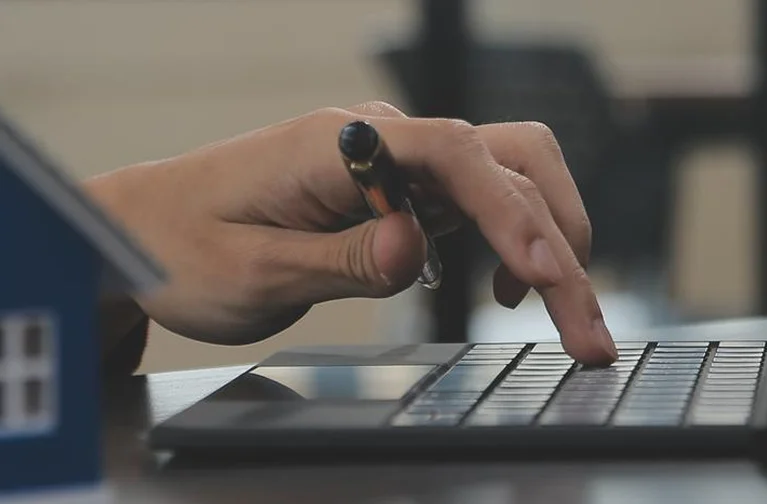 a hand holding a pen on a keyboard