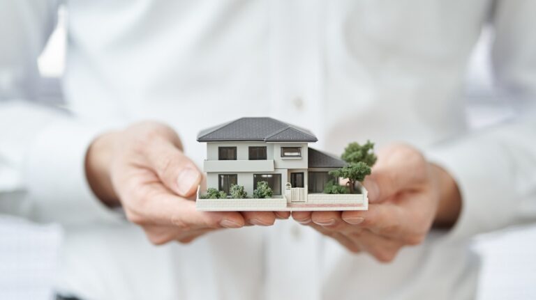 Man is holding house model
